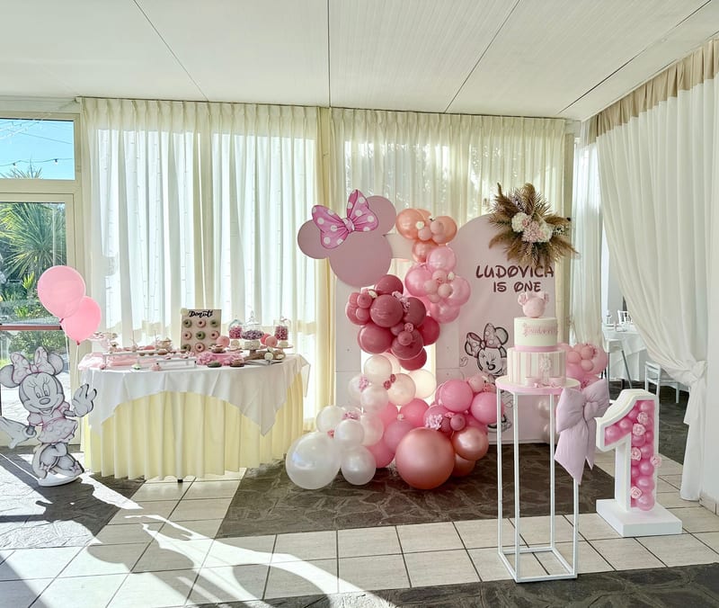 Allestimento primo compleanno a tema topolina con palloncini rosa e bordeaux