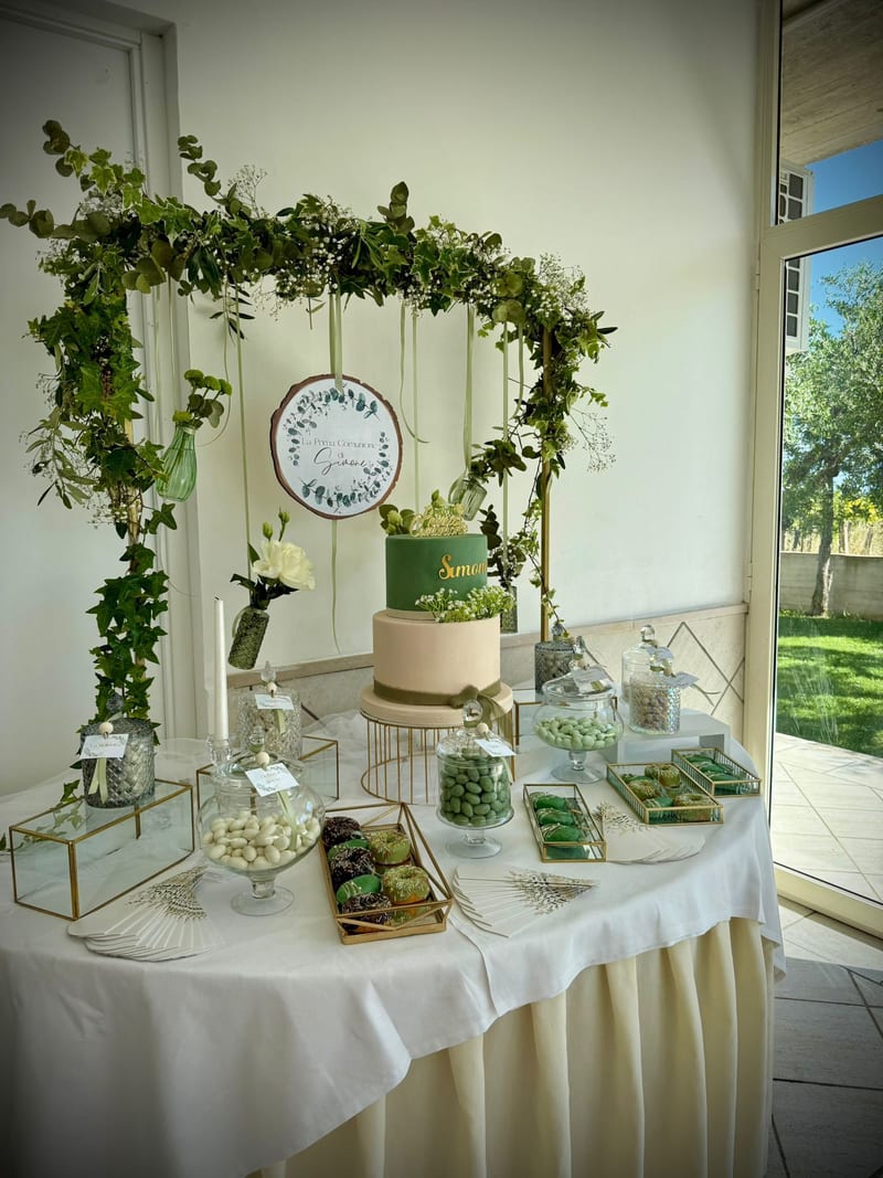 Tavolo della torta nuziale con arco di verde e ortensie bianche in veranda