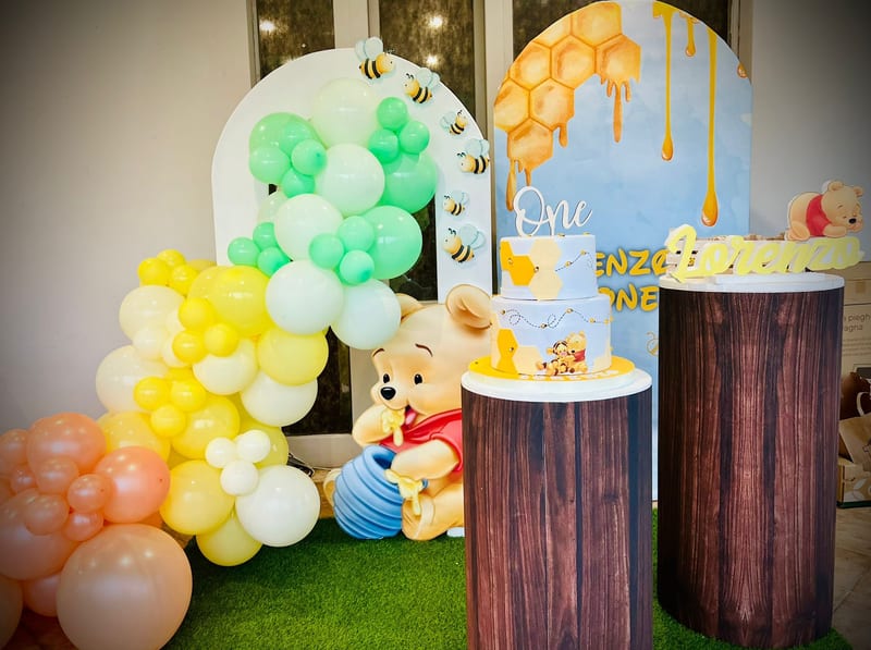 Allestimento per primo compleanno a tema orsetto e miele con palloncini gialli, verdi e azzurri