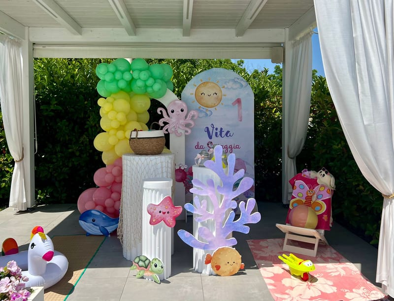Allestimento compleanno a tema mare con palloncini pastello e decorazioni marine in giardino