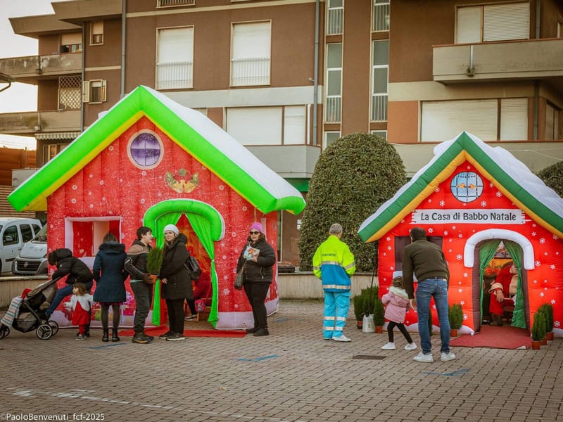 Casette gonfiabili del villaggio di Natale con visitatori in fila all'ingresso