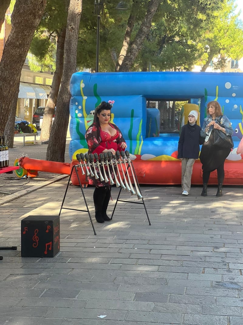 Artista suona i bicchieri musicali accanto al gonfiabile durante l'evento in piazza